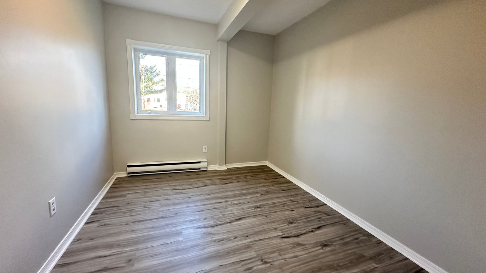 a room with a wood floor and a window